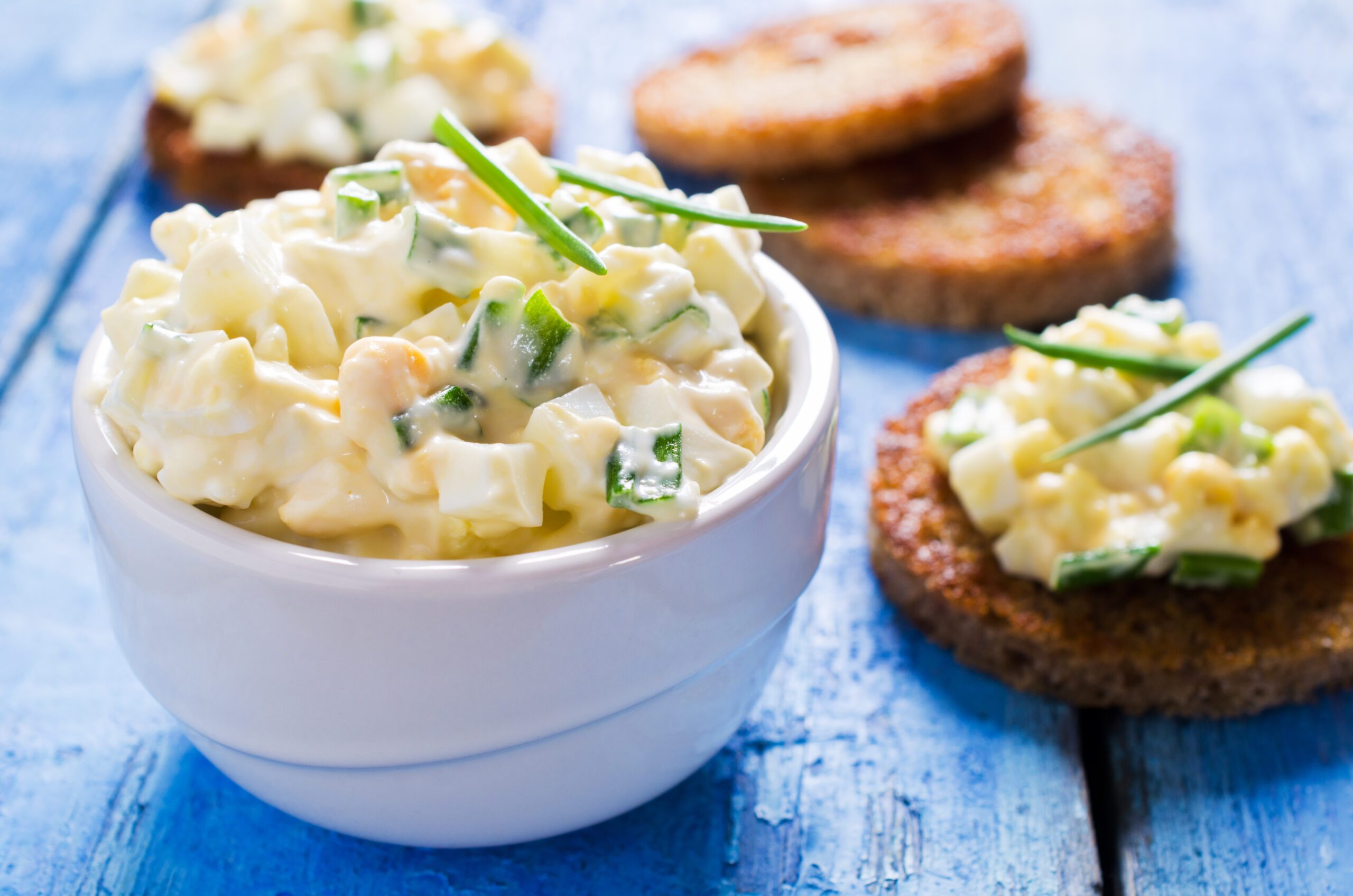 Egg salad with chives on a wooden background