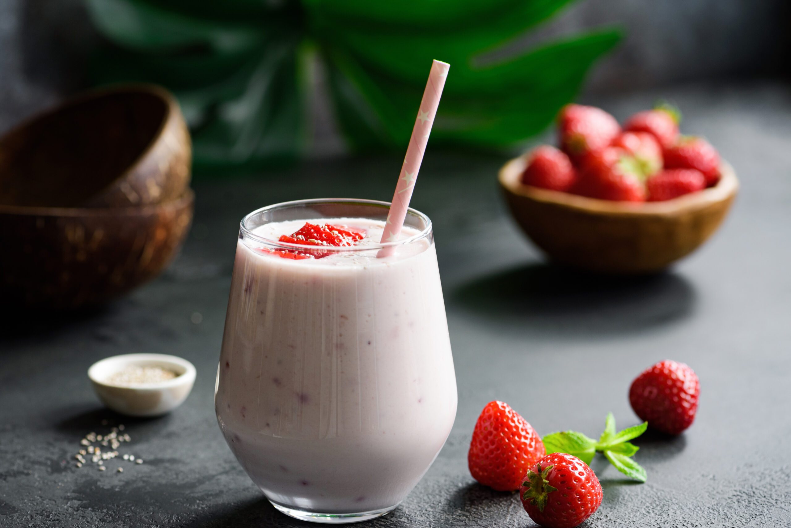 Strawberry coconut smoothie or a glass with a drinking straw