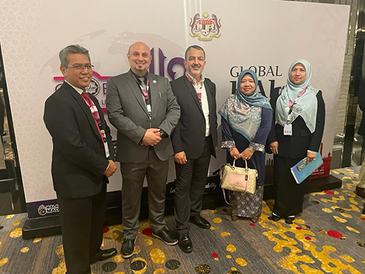 Photo of five people in front of a backdrop for the Global Halal Summit 2023