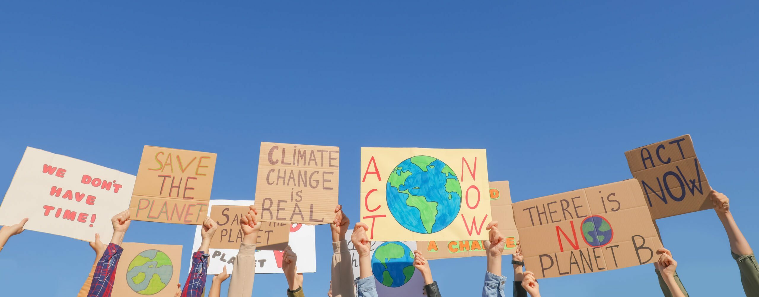 Group of people with posters protesting against climate change outdoors, closeup
