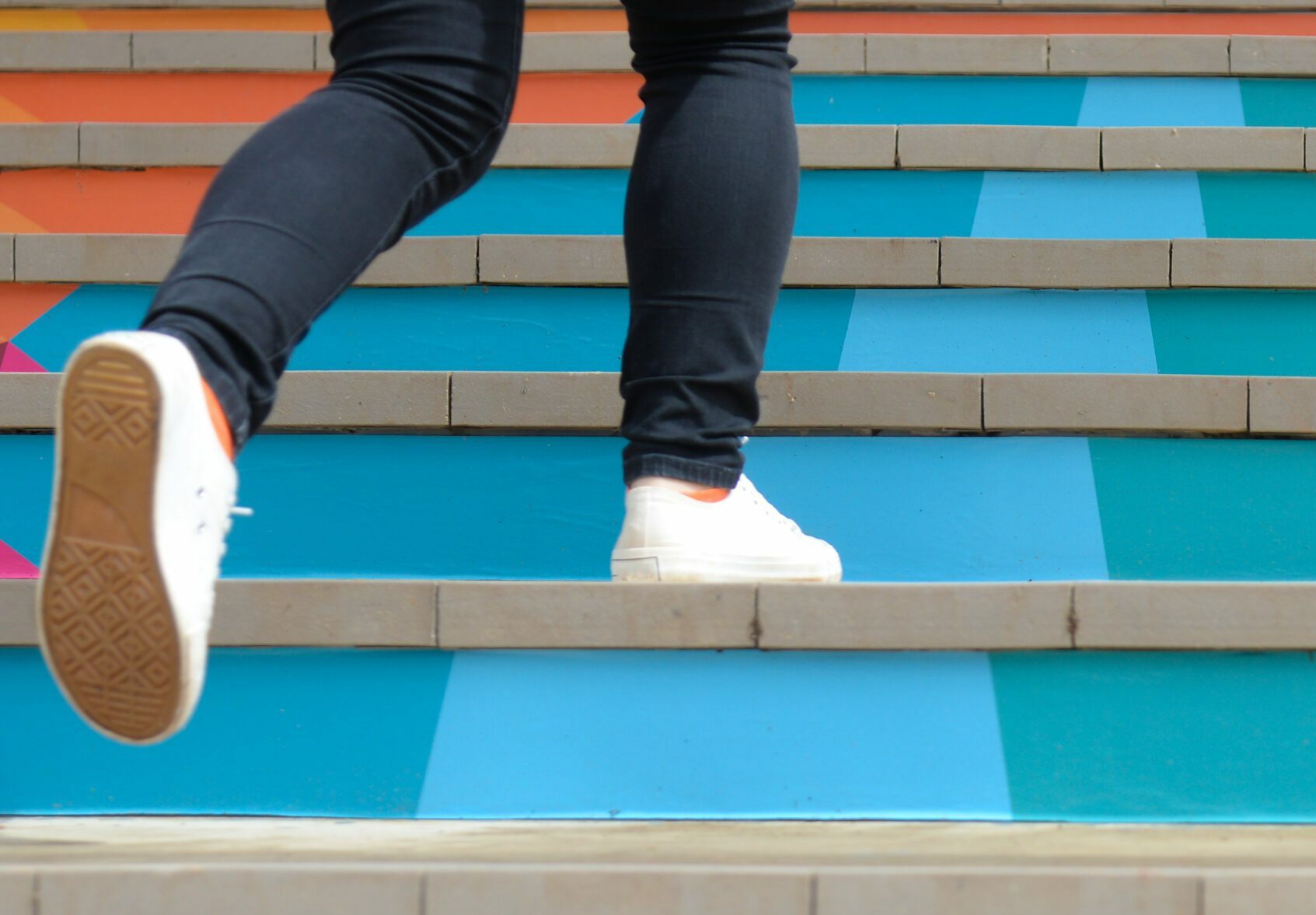 Lower part of teenage girl in casual shoe walking up outdoor colorful stair,teenage lifestyle successful concept