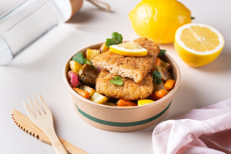 ood to reduce carbon footprint. Vegan Plant based fish with crispy batter and roasted vegetables in a zero waste reusable recycling cardboard packaging