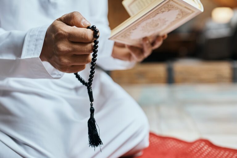 Man reading Quran and has tasbih in other hand