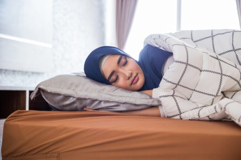 portrait of muslim woman sleeping in bed with hijab on
