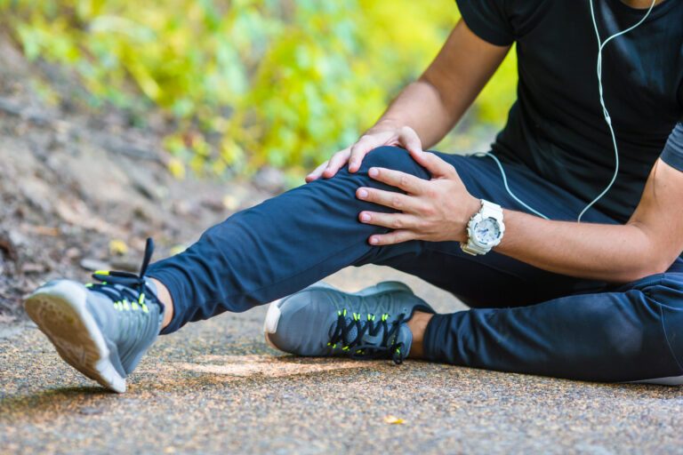 Male athlete suffering from pain in leg while exercising outdoor