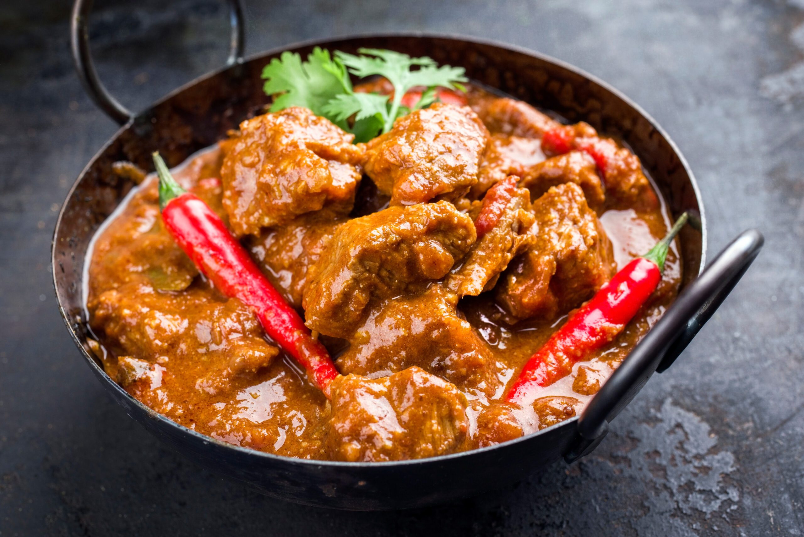Traditional Indian curry lamb masala as close-up in a Korai