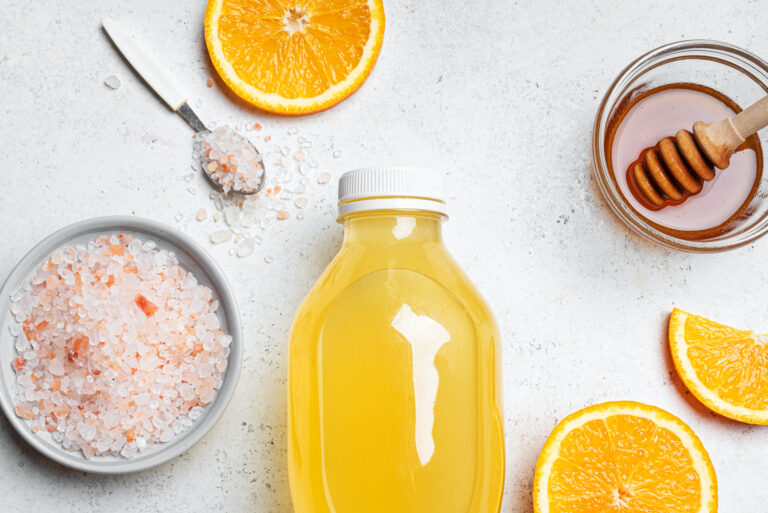 Isotonic energy drink. Bottle of homemade yellow transparent liquid, sport electrolyte water with hymalayan salt, orange and honey.